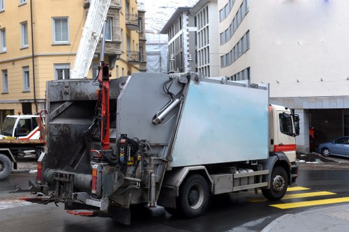 Workers removing commercial waste with safety signs visible